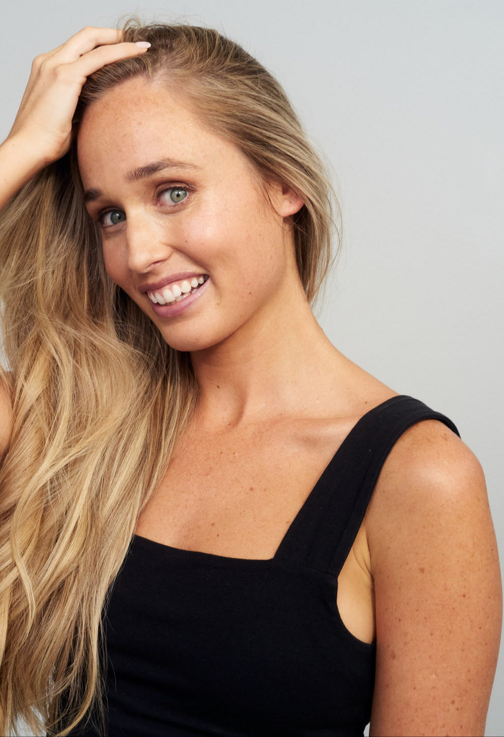 A blonde woman smiling with a full head of healthy hair