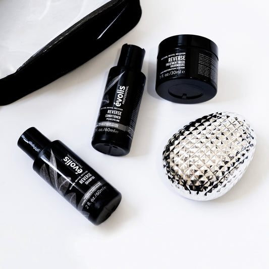 A stylized photo of the Evolis Reverse products in travel size (shampoo, conditioner, & mask)